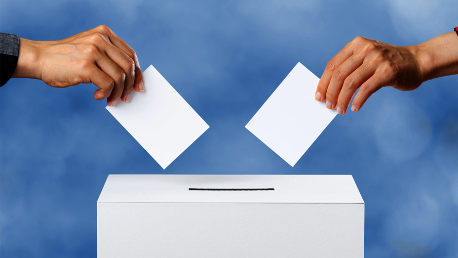 Zwei Wähler werfen Wahlscheine ein