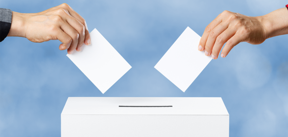 Zwei Wähler werfen Wahlscheine ein